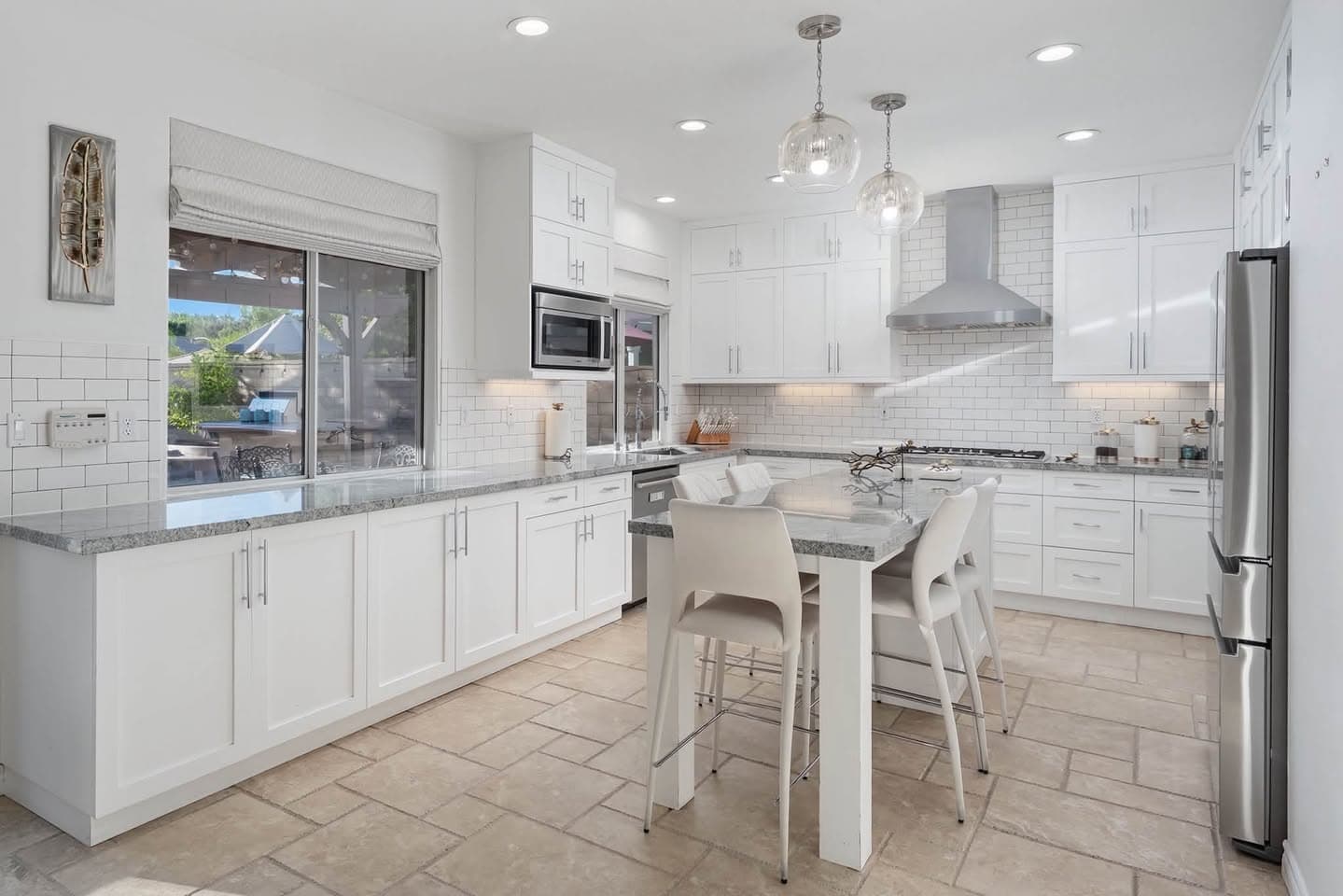 Updated white kitchen with a stone island — sample interior